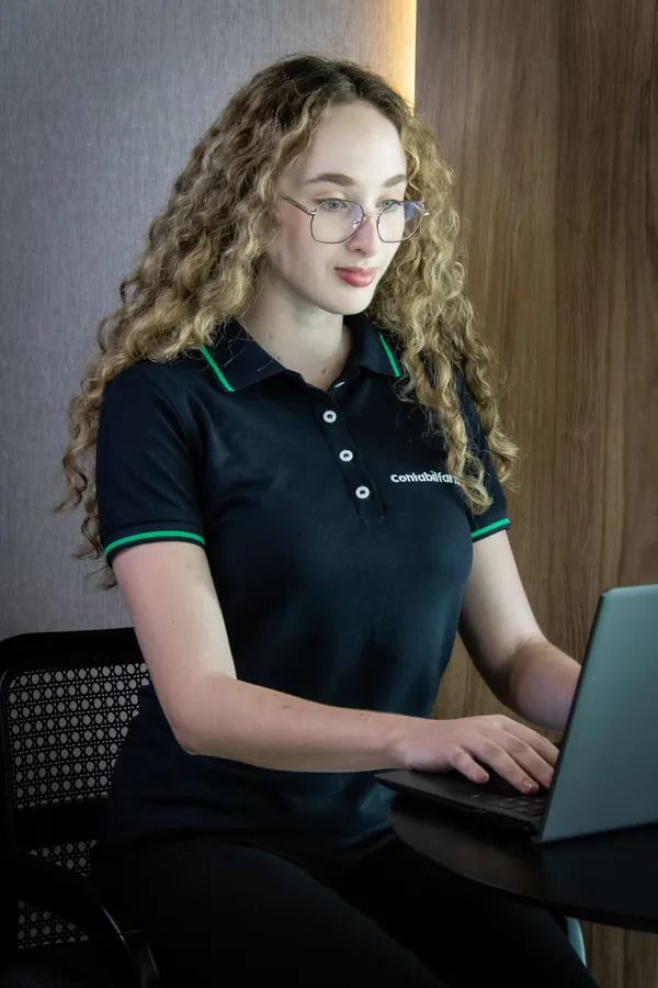 Colaboradora de óculos trabalhando no notebook