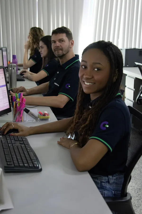 Equipe trabalhando lado a lado nos computadores do escritório