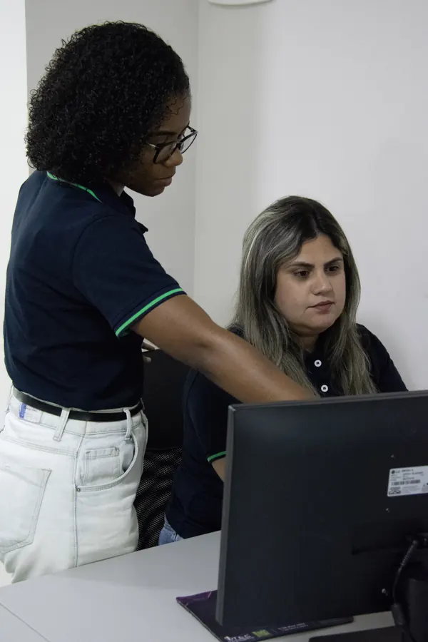 Duas colaboradoras analisando dados juntas no computador