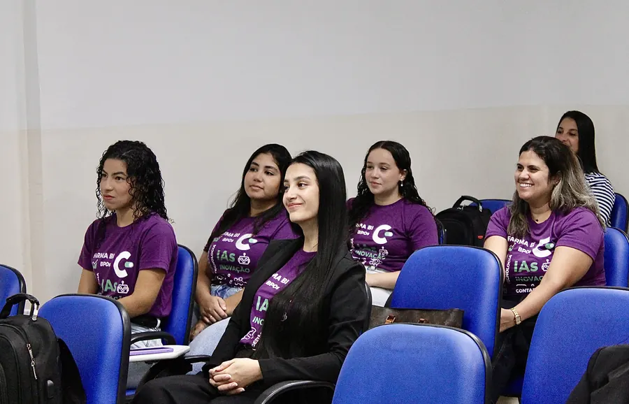 Equipe com camisetas roxas da Contabilfarma acompanhando uma apresentação